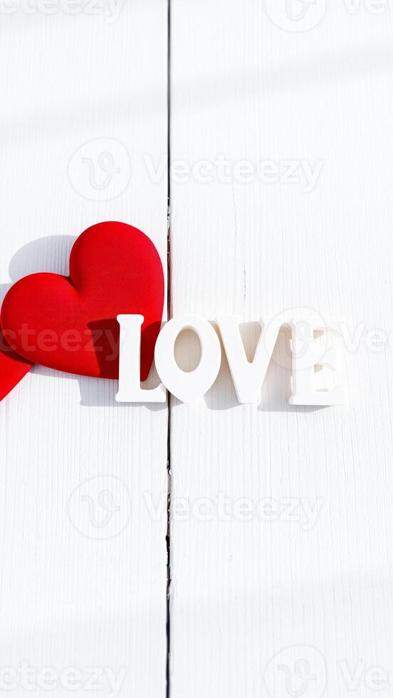 red heart white letters on a wooden surface photo
