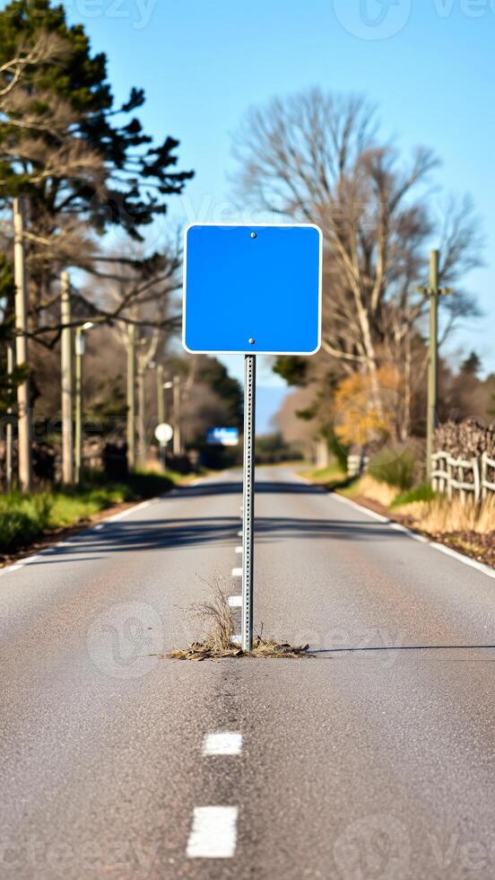 blank blue sign stands the middle a paved road photo