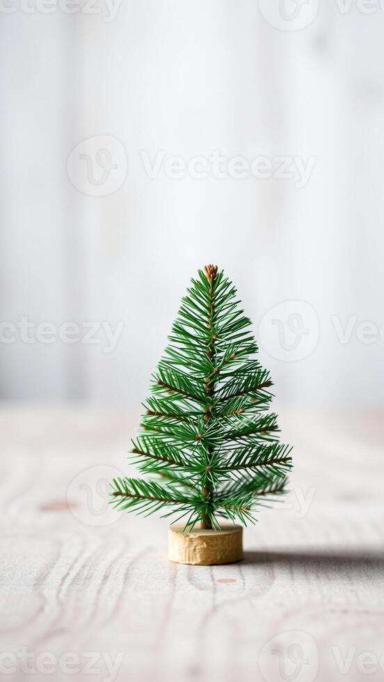 miniature artificial evergreen tree on a light wood table photo