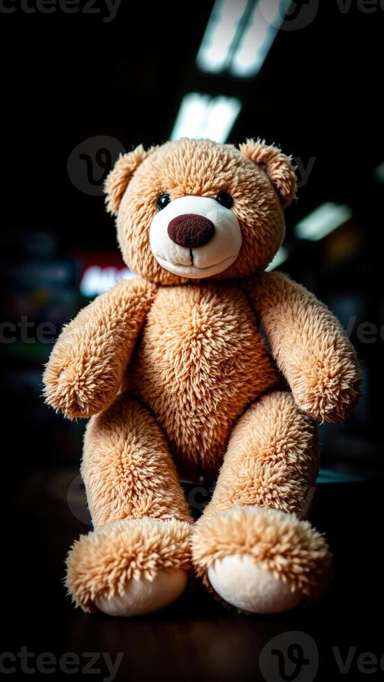 brown plush teddy bear sits on a dark surface photo