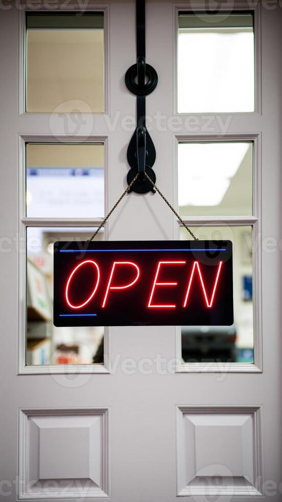 red neon open sign hangs on a white door photo