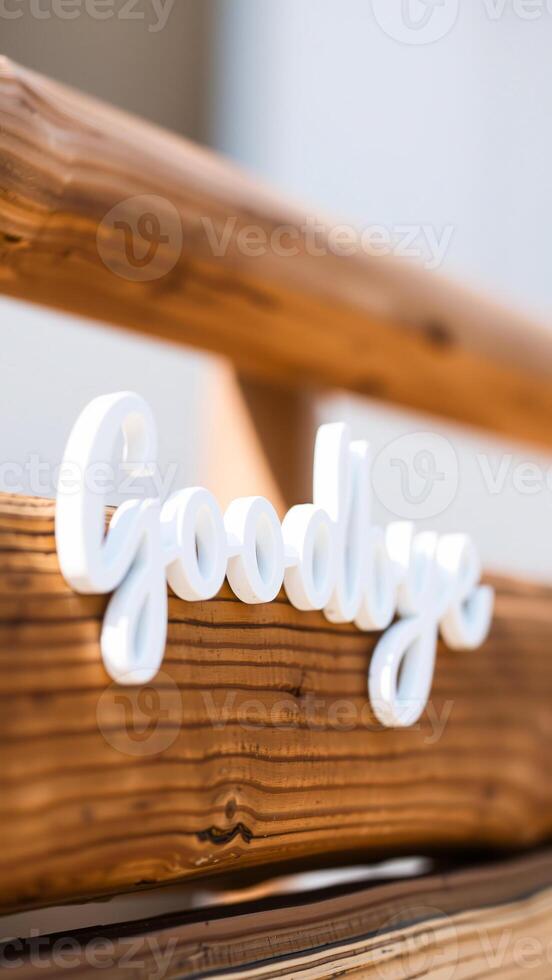 white goodbye sign on a rustic wooden surface photo