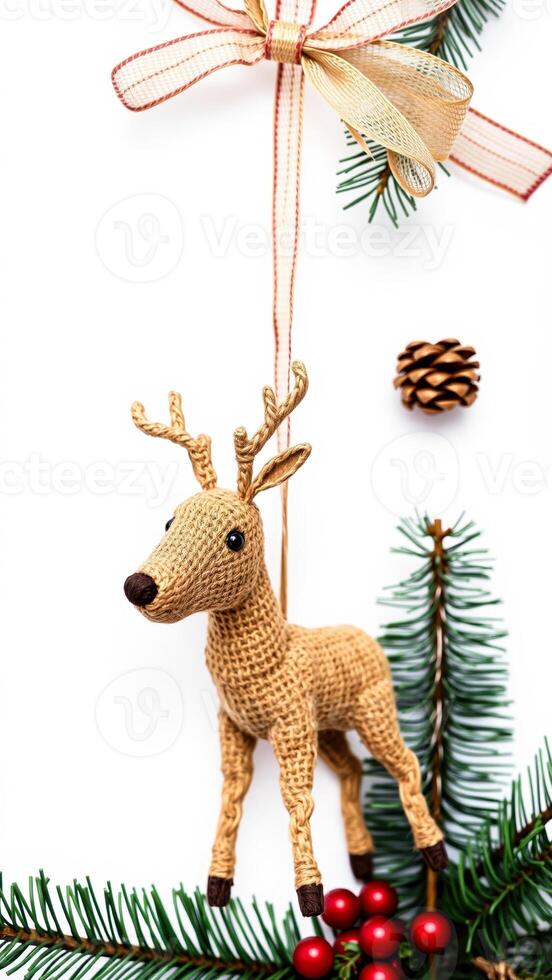 crocheted reindeer ornament hanging with pine branches a golden bow photo