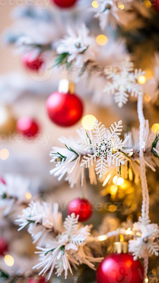feathery tree branch adorned with a silver snowflake red baubles photo