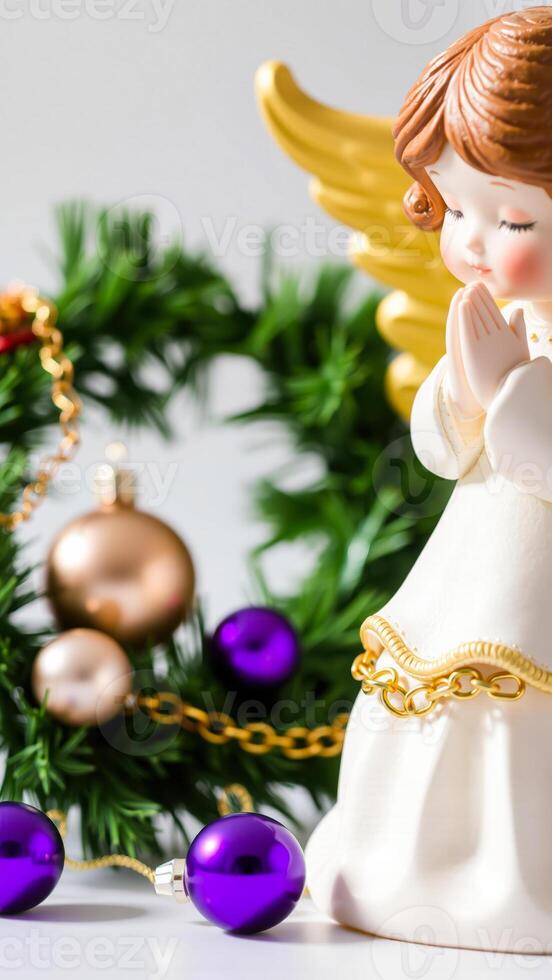 porcelain angel figurine with golden wings beside a festive wreath photo