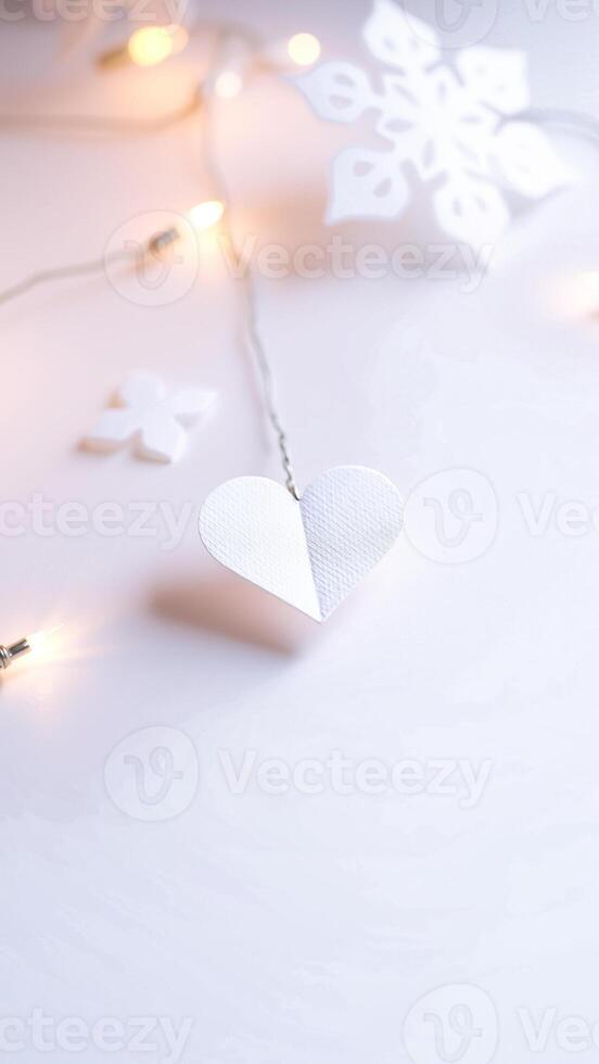 delicate white paper heart hanging from a string lights photo