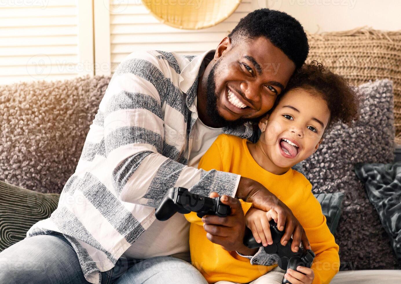 African american dad and daughter have fun playing battle game on console photo