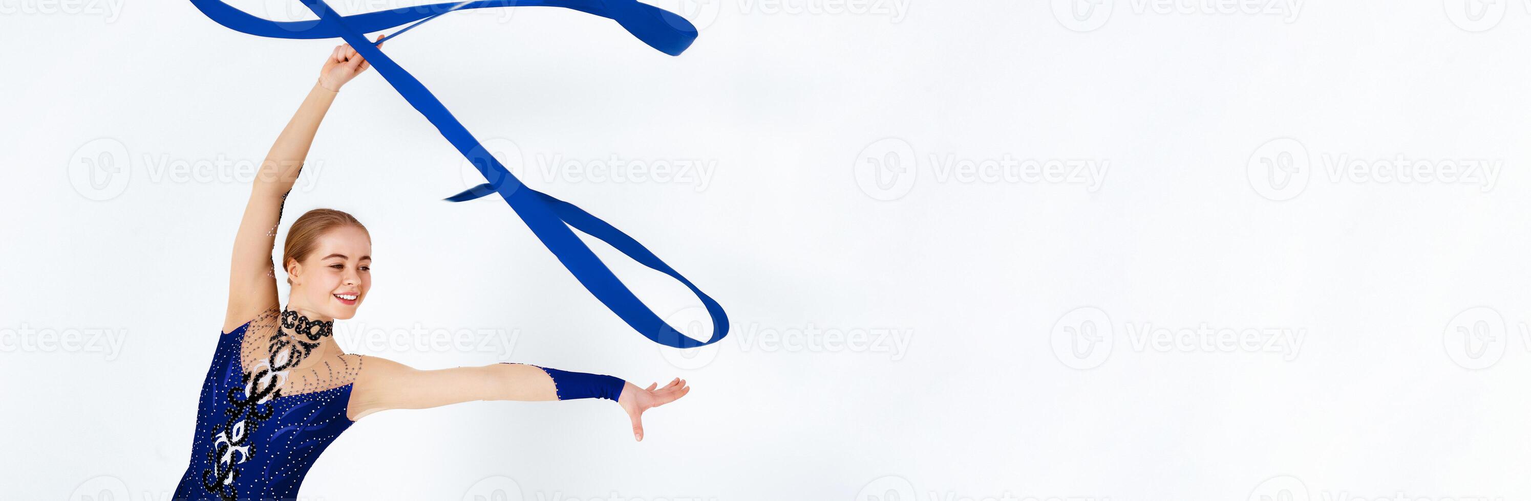 Rhythmic gymnastics exercises. Young slender girl practicing with red ribbon on white background photo