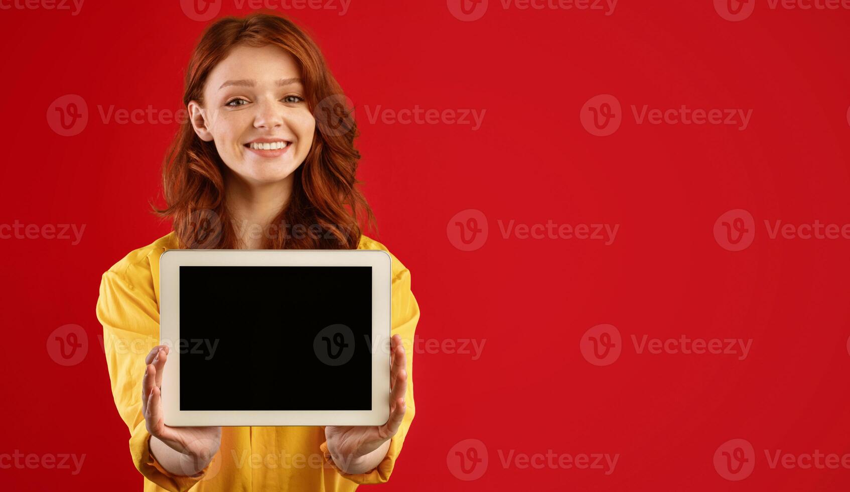 Cheerful Girl Showing Digital Tablet Empty Screen Smiling To Camera Standing On Green Background In Studio. Copy Space, Mockup photo