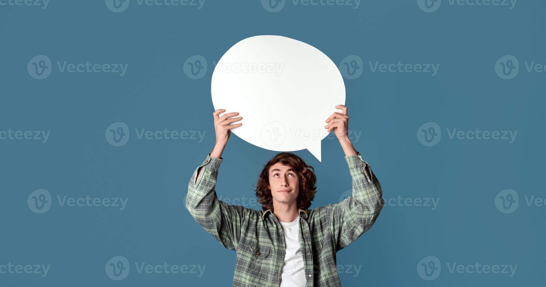 Portrait of handsome teenager with empty speech bubble on color background, copy space photo