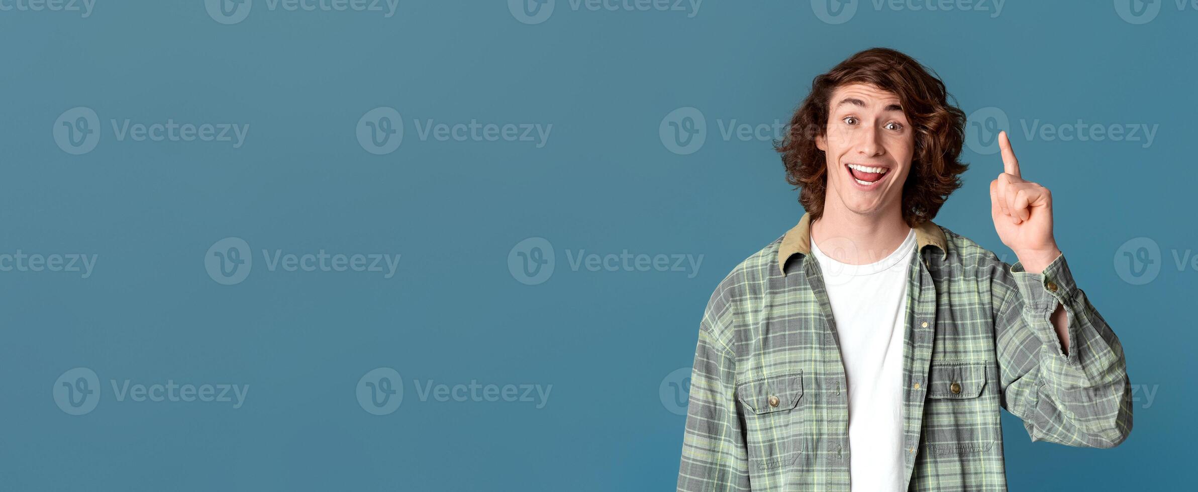 Creative idea. Cheerful millennial guy showing EUREKA gesture on turquoise background photo