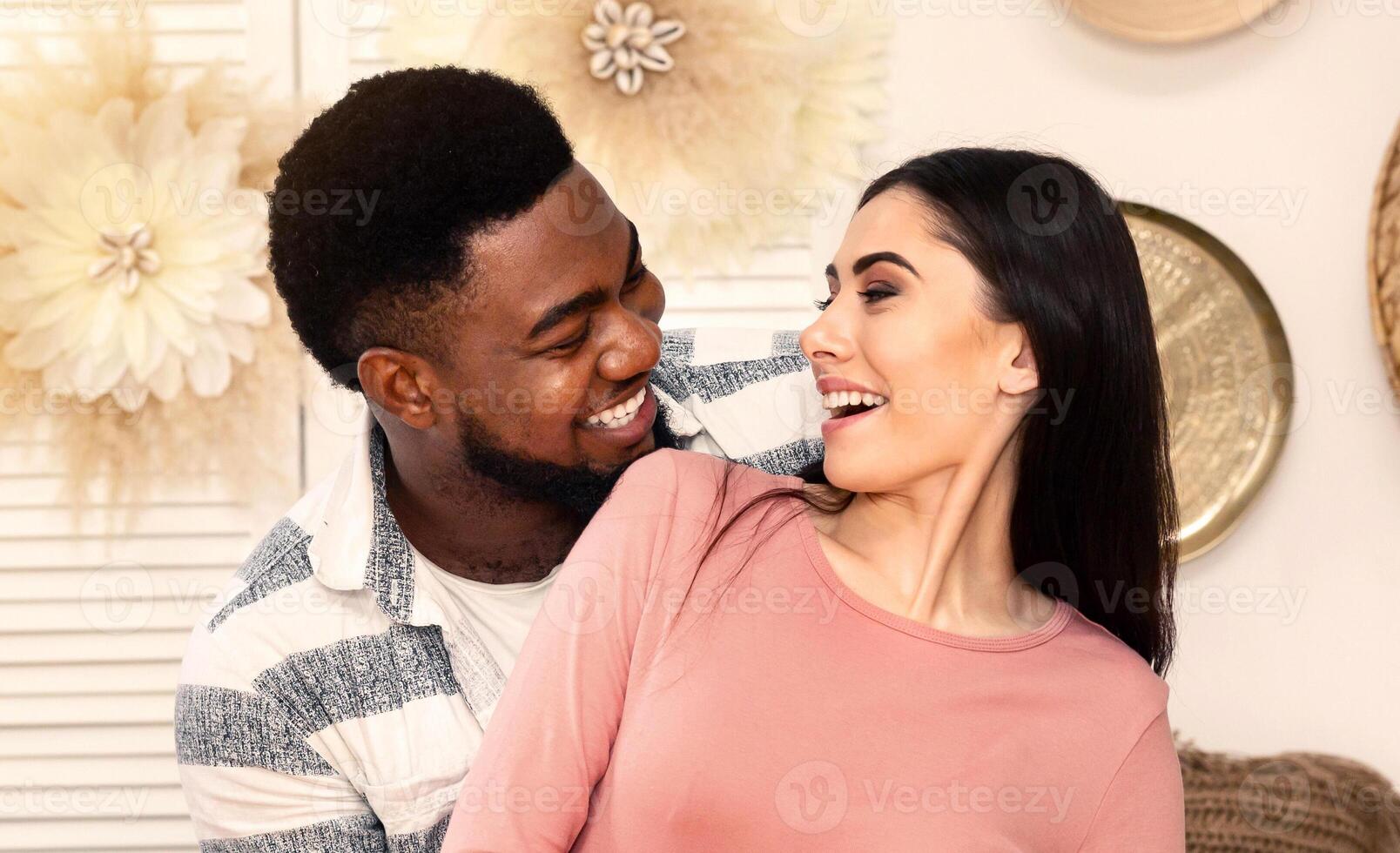 Love concept. African american husband and european wife smiling at each other photo