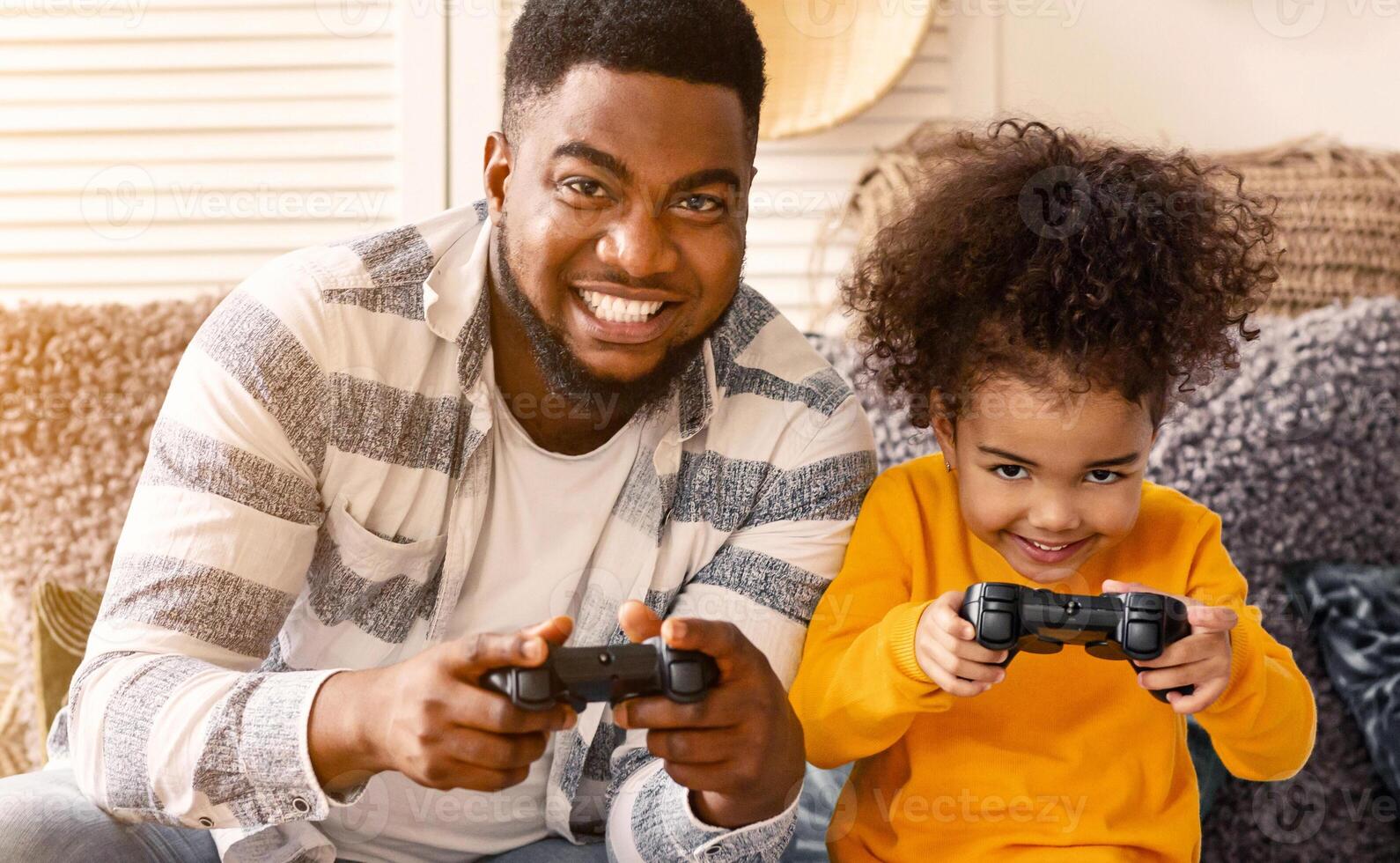 Smiling african american father and daughter play computer games during coronavirus quarantine photo