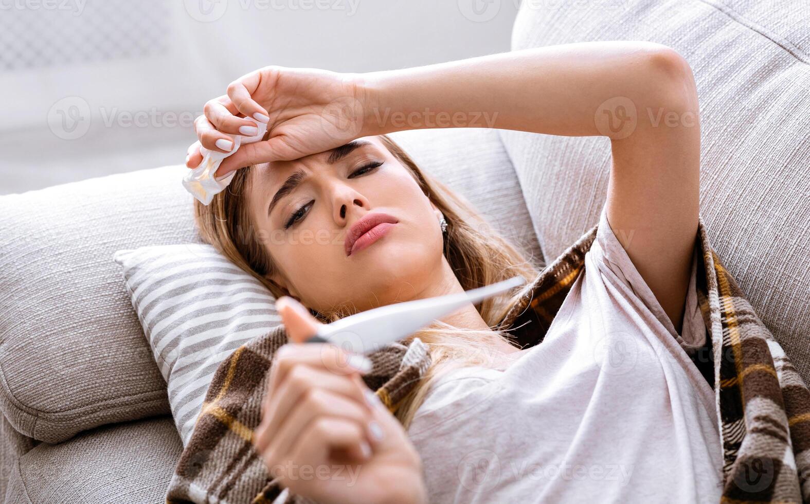 Bed rest concept. Sick girl looking at thermometer, panorama photo