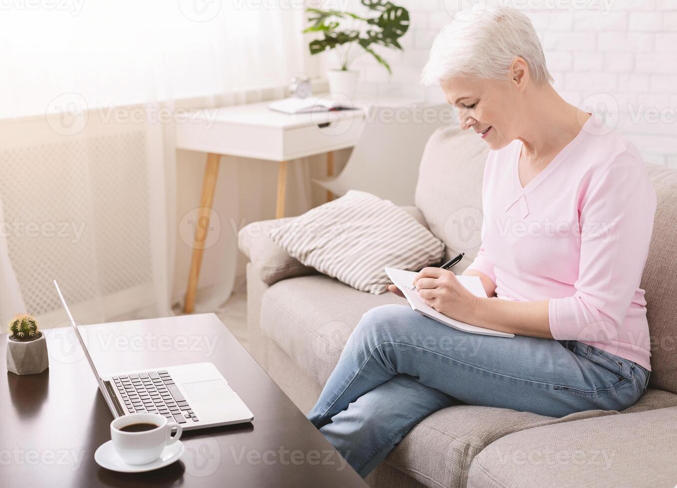 Well organized senior lady writing to-do-list and plans for retirement, empty space photo