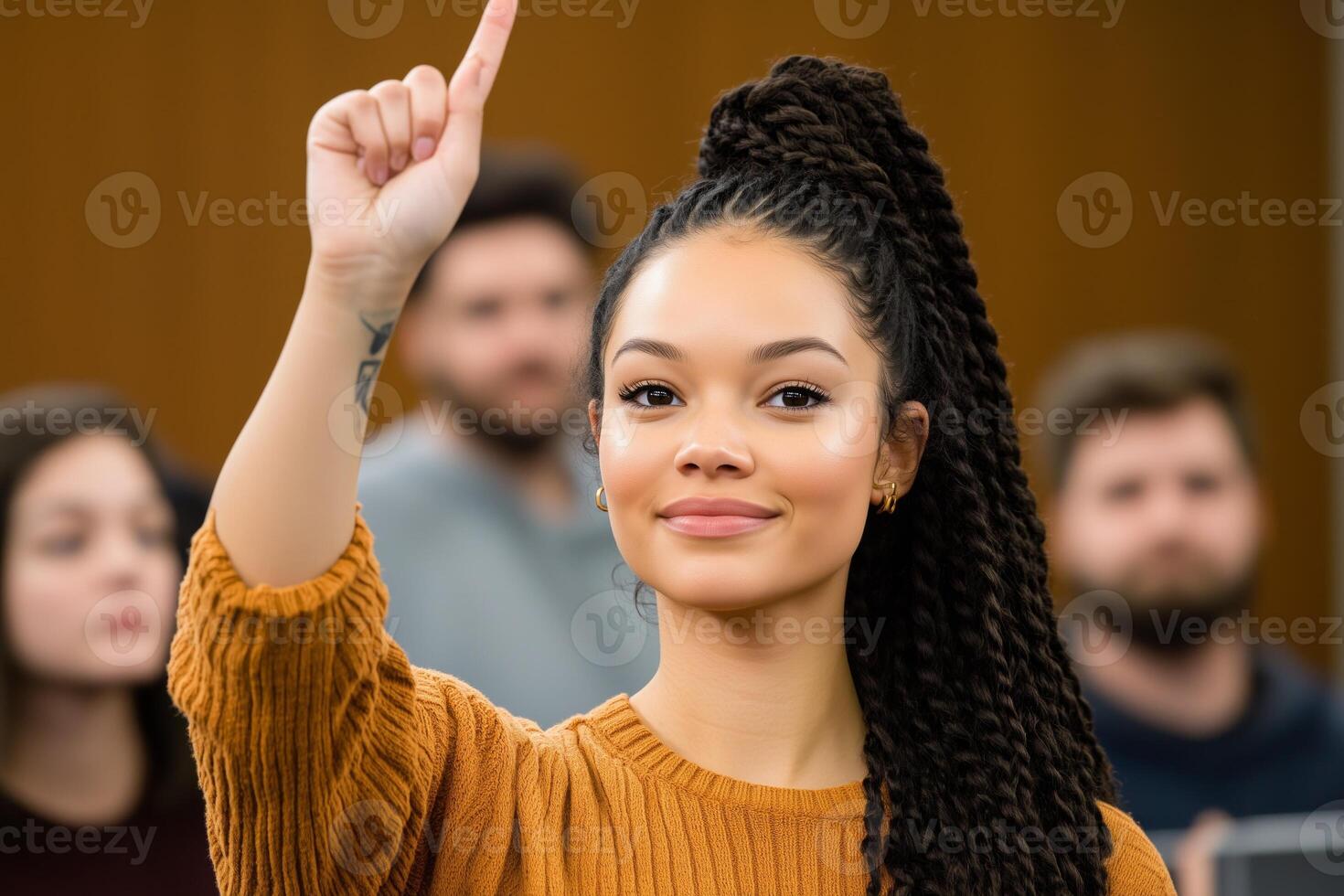 Eager student raising hand in diverse lecture hall during engaging classroom discussion on a bright day photo