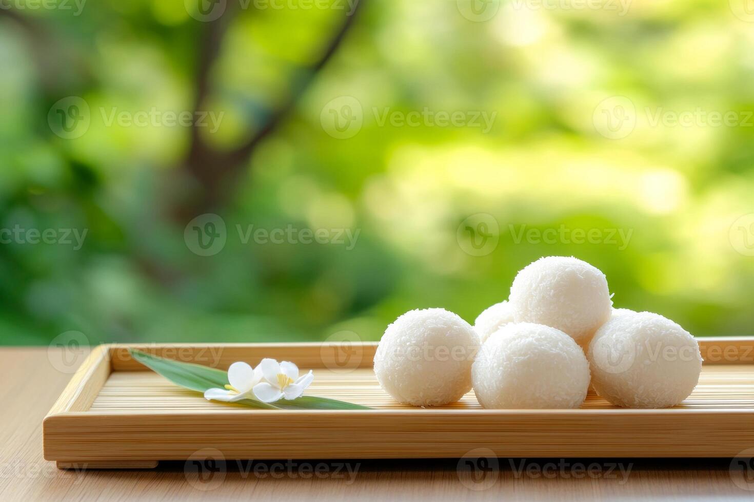 Sweet coconut balls arranged on a bamboo tray with warm morning light in a Japanese inspired setting photo