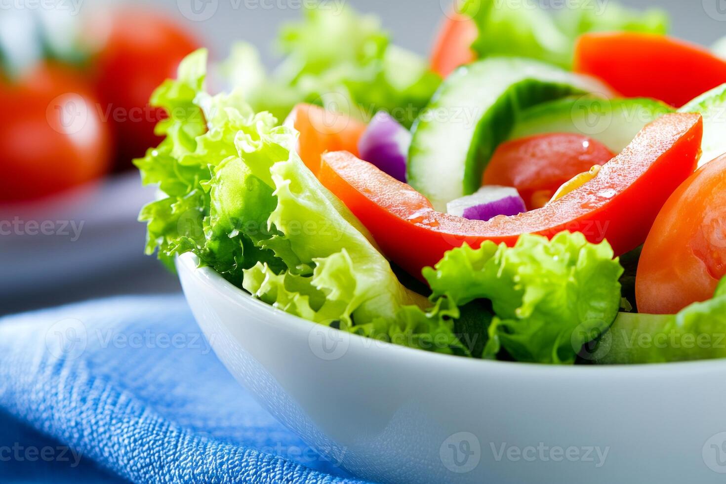 Fresh and vibrant salad bowl featuring green vegetables and colorful toppings on a blue napkin photo