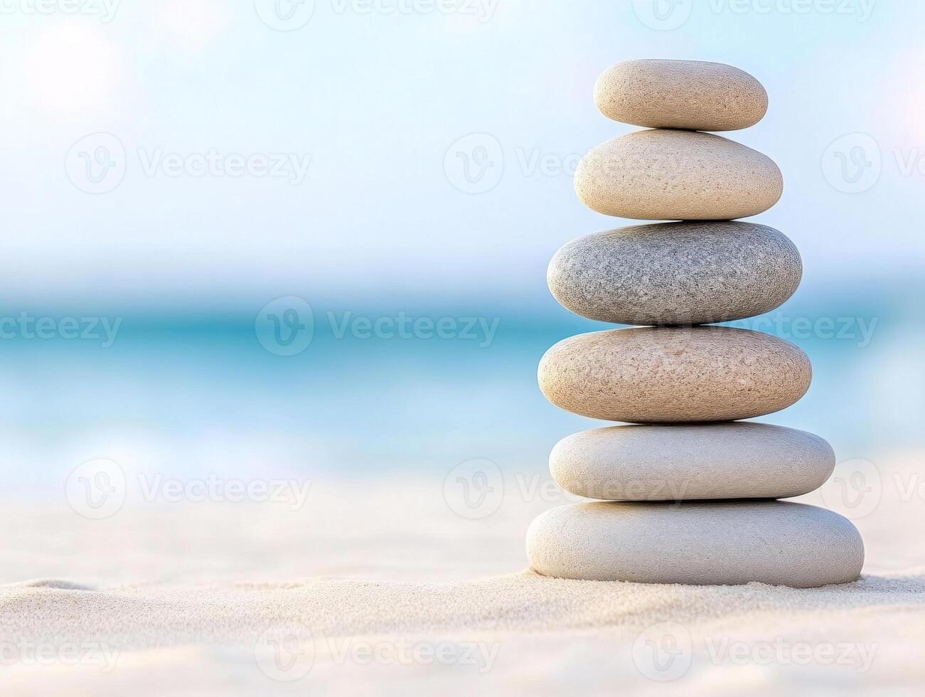 Stacked zen stones on a sandy beach with calm waves creating a tranquil atmosphere of harmony and balance photo