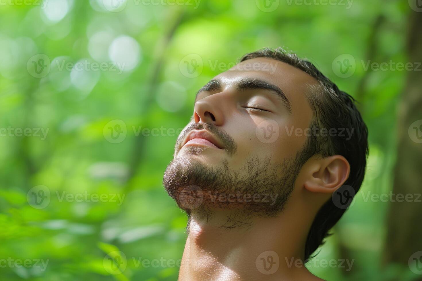 A man relaxes in a green forest while practicing mindfulness and enjoying nature on a peaceful day photo