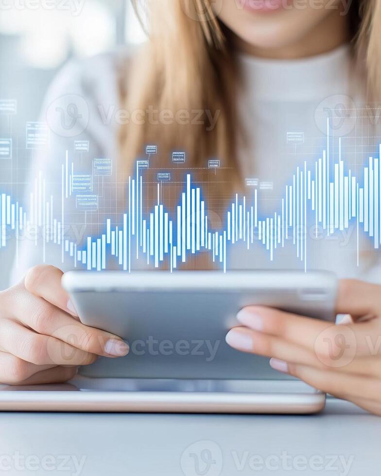 Young woman engages with a transparent tablet in a futuristic office featuring floating financial data analytics photo