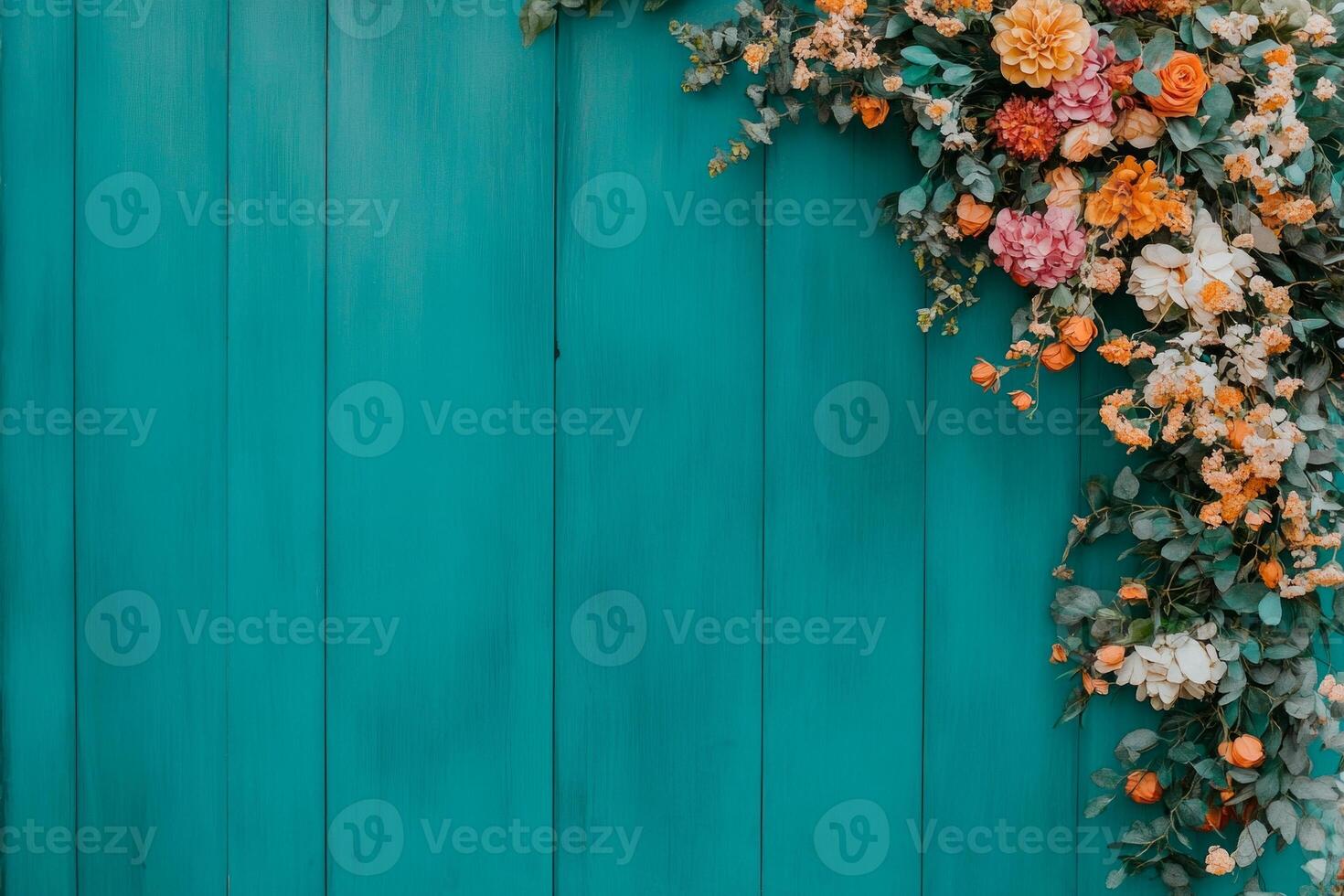 Boho garden setting with vibrant flower garland arch and wooden backdrop surrounded by lush greenery photo