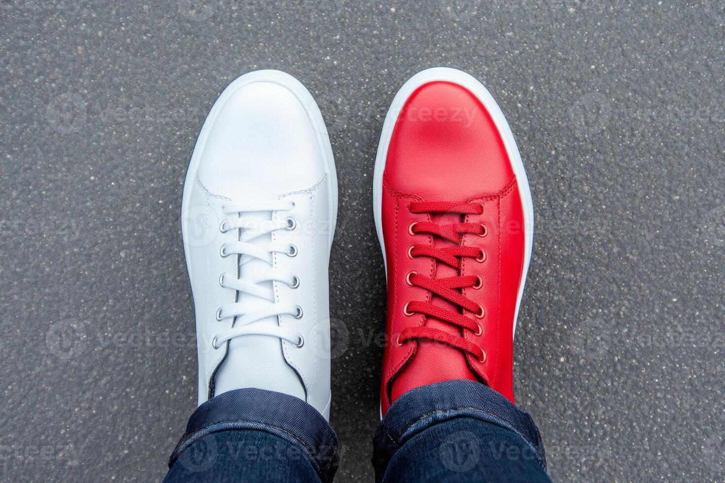 A unique expression showcased through mismatched red and white shoes worn on a minimalist background photo