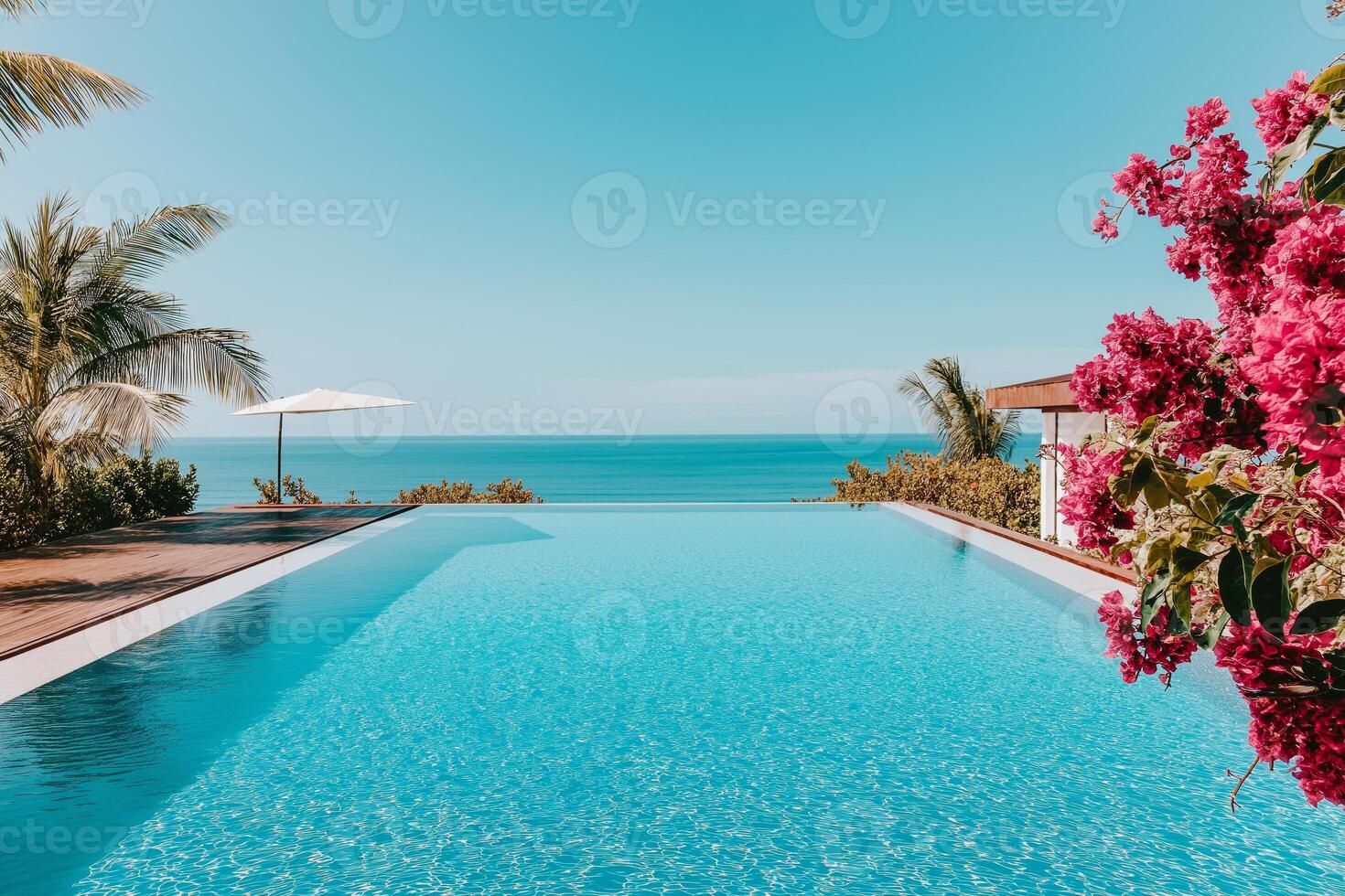 Relaxing infinity pool at a tropical resort overlooking the ocean with white sand beaches and vibrant flora photo
