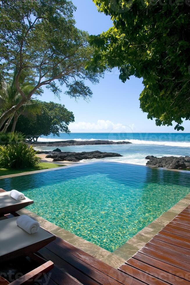 Relax by the shimmering resort pool overlooking the ocean and tropical paradise on a sunny day photo