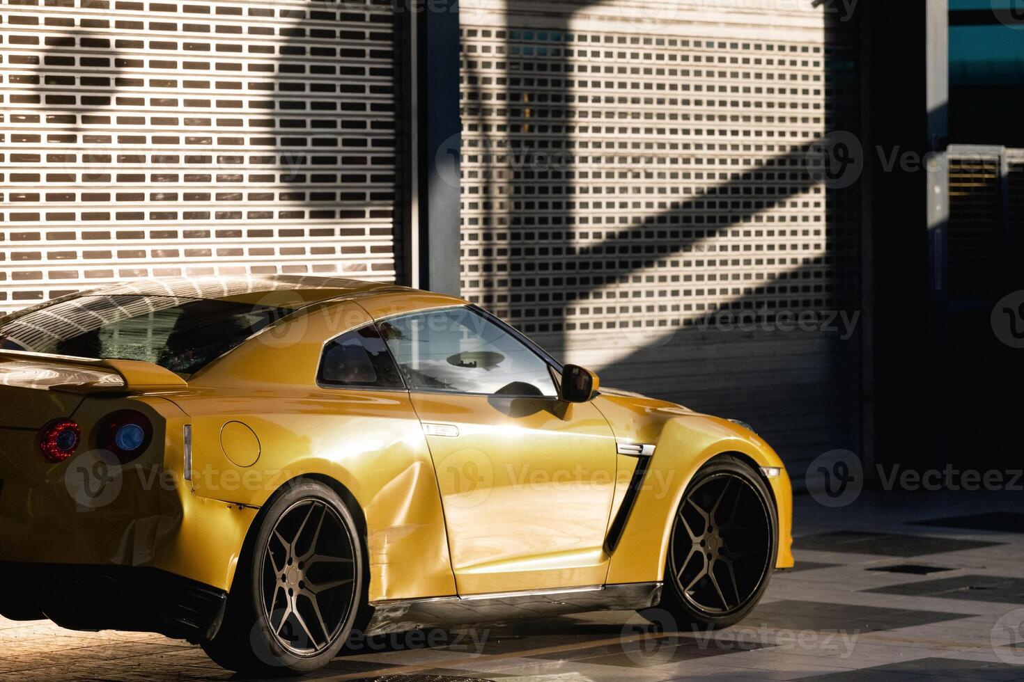 A crumpled orange sports car in the sunset-lit sunlight after a traffic accident.rushed parts photo