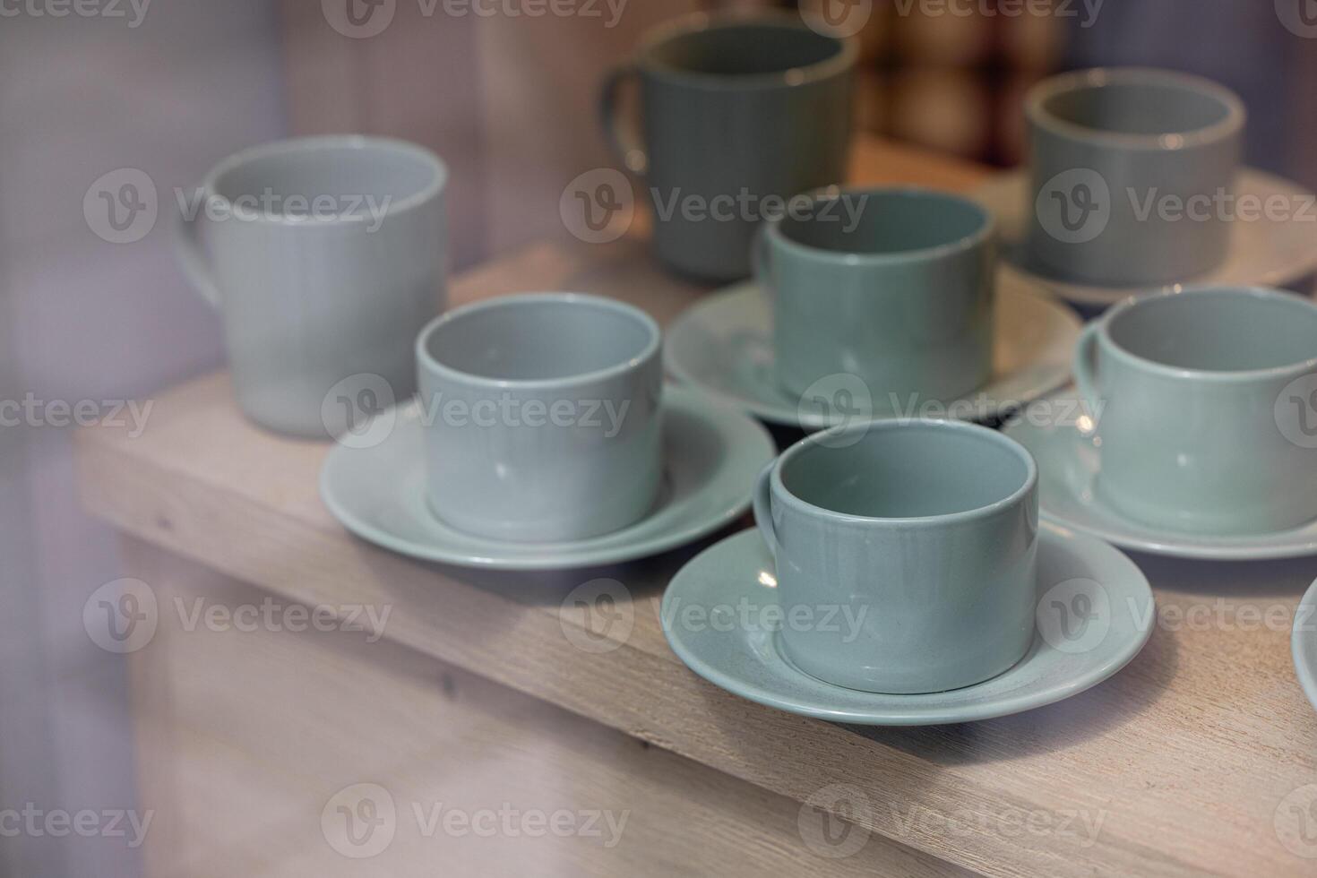 Colorful cups with saucers displayed in a store window. photo