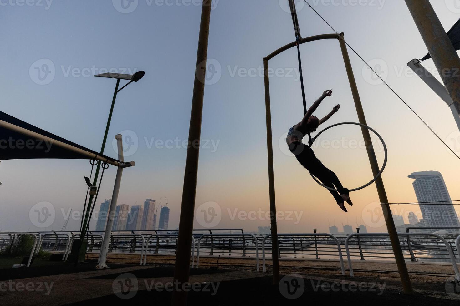 Sport exercises with aerial silk outdoor, sky background. photo