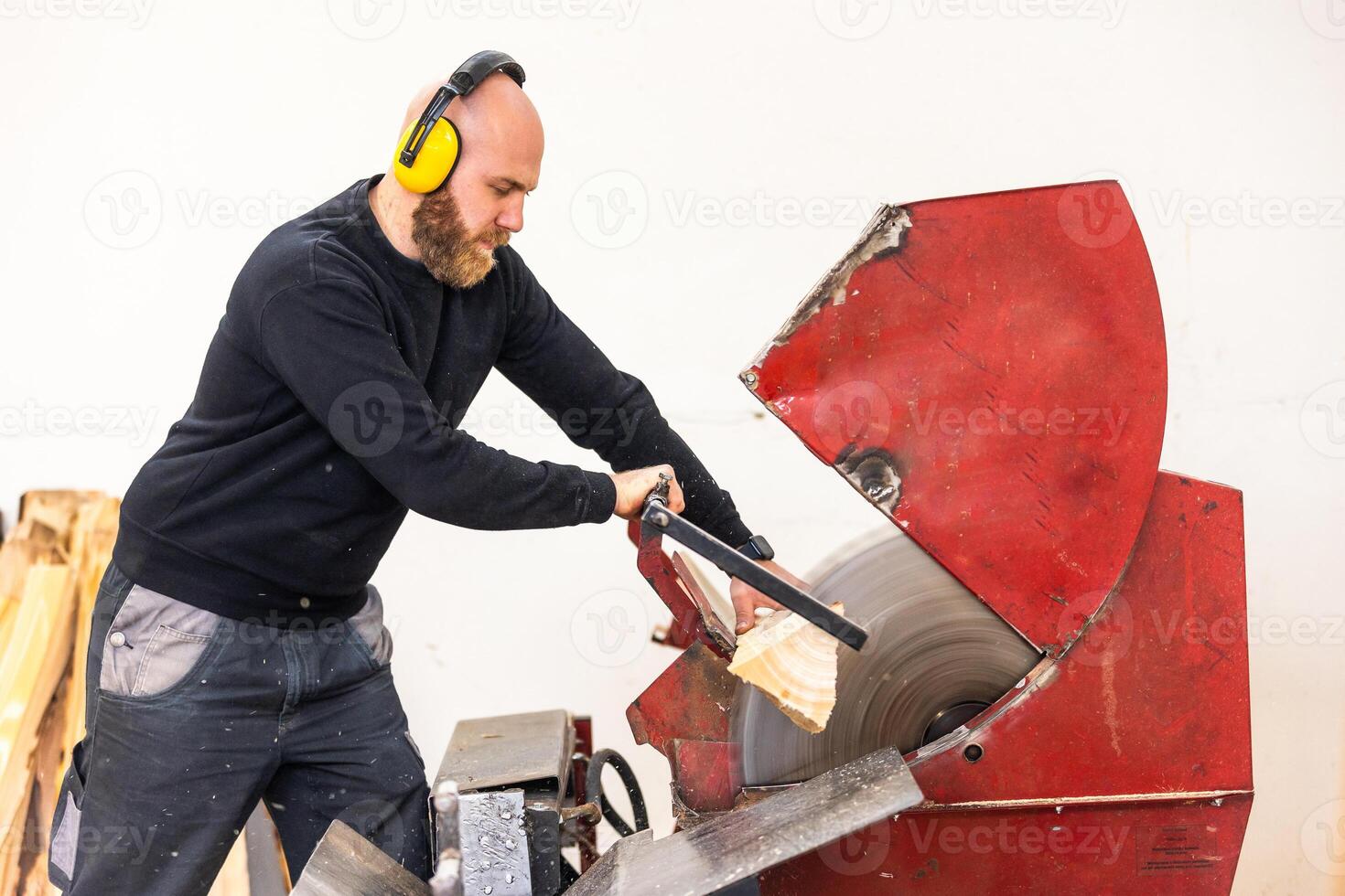 Professional carpenter cutting raw wood to firewood pieces, manufacturing wood concept photo