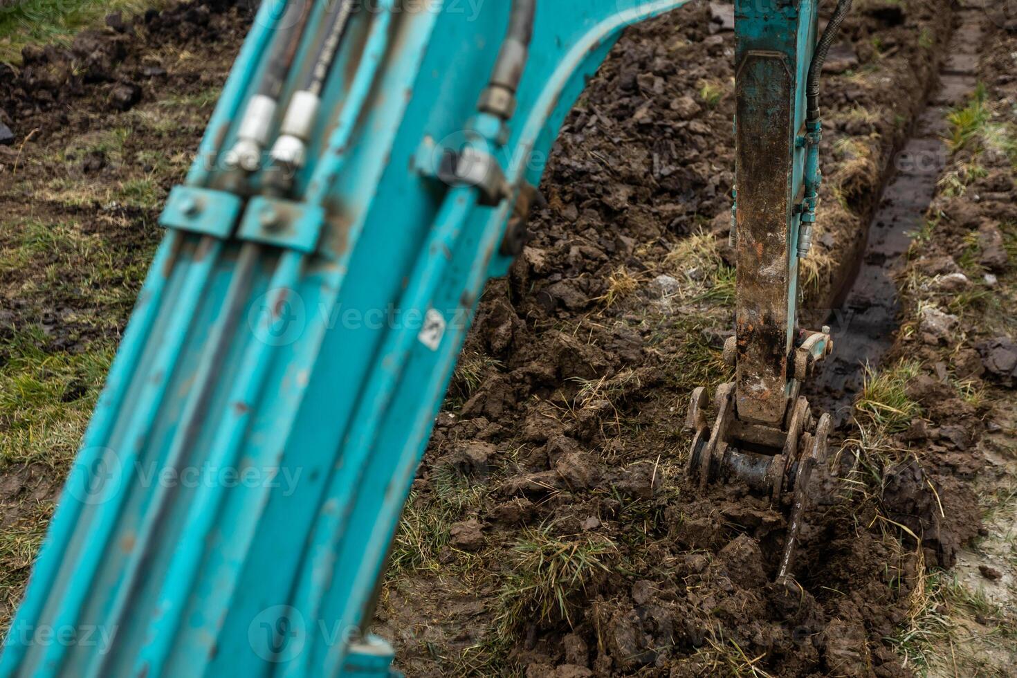 Close up of excavator or digger digging some a soil or clay, industrial concept photo