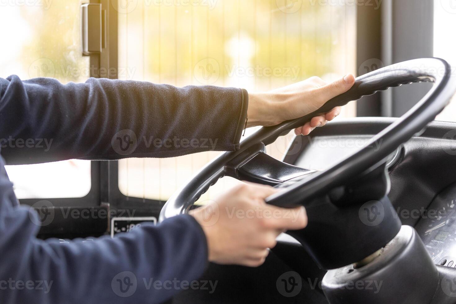 Close up of bus driver hands on the steering wheel during driving the bus, public transport concept photo