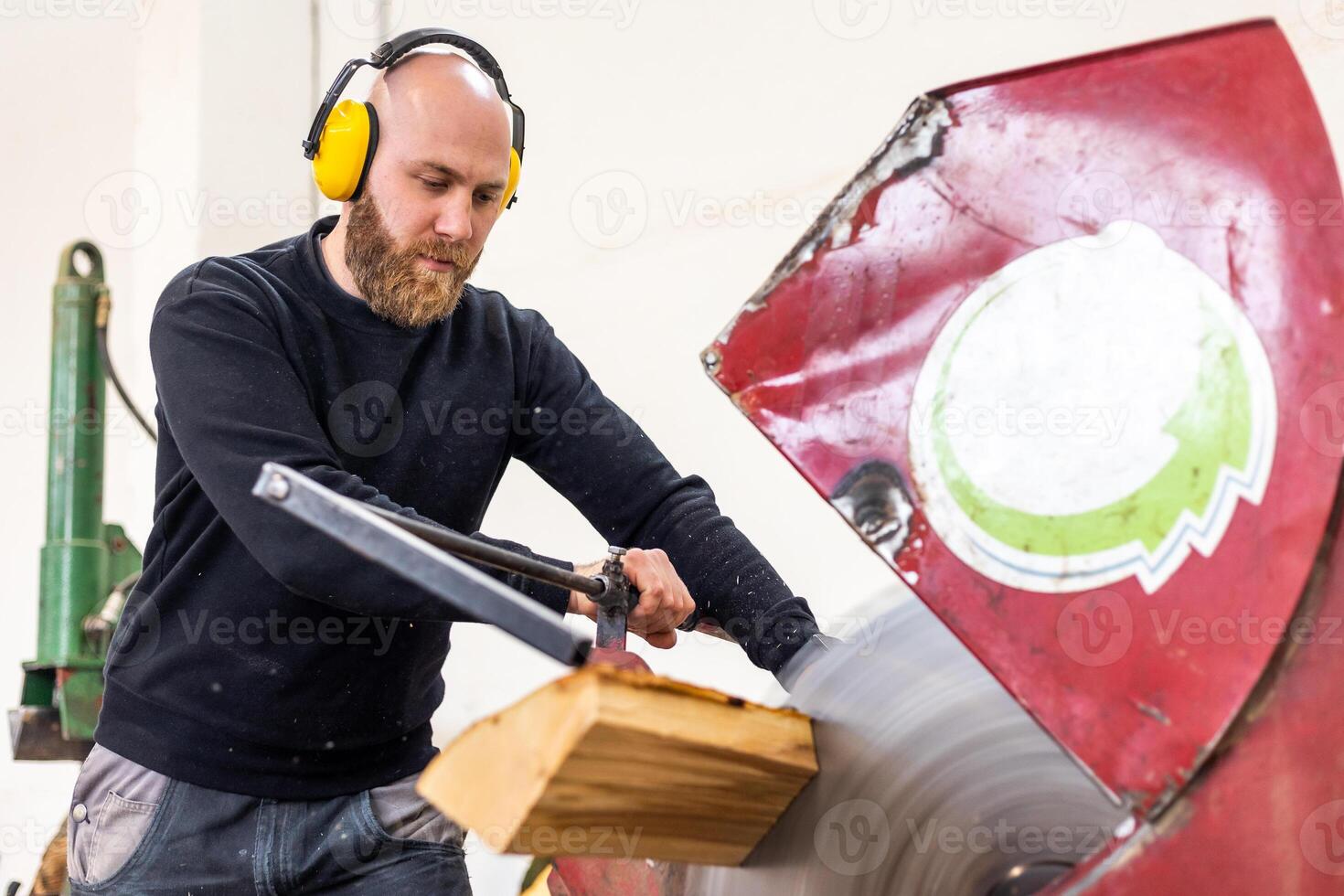 Professional carpenter cutting raw wood to firewood pieces, manufacturing wood concept photo