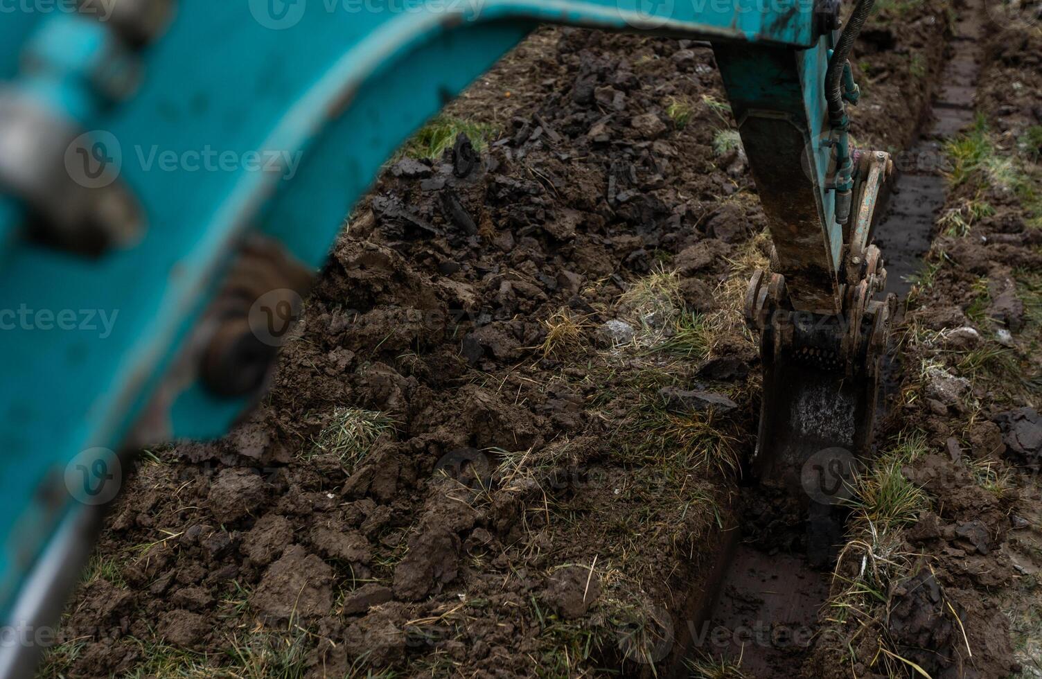 Close up of excavator or digger digging some a soil or clay, industrial concept photo