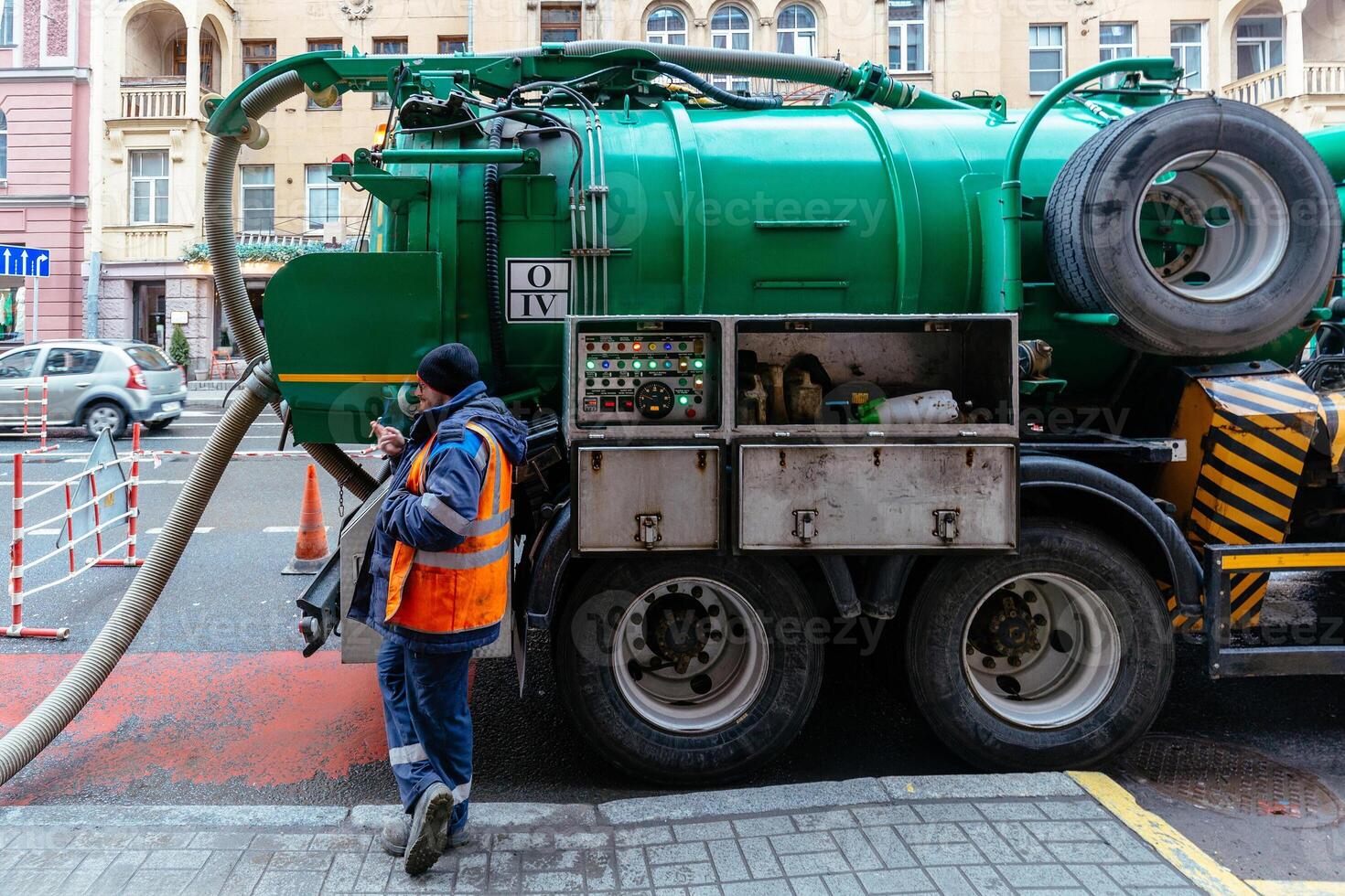 Worker near sewage cleaning vacuum truck. Septic cleaning vacuum service and maintenance photo
