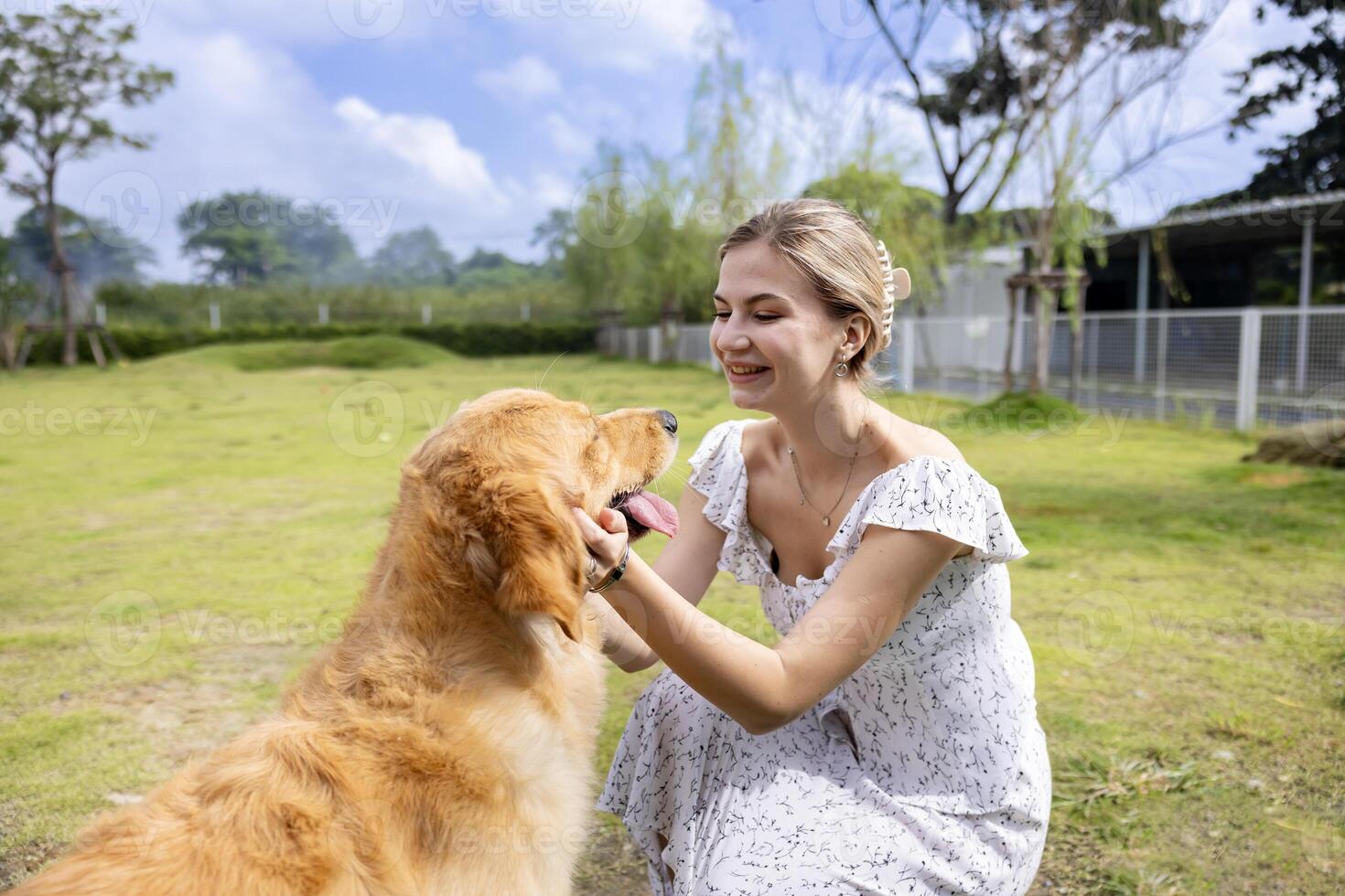 Caucasian woman hugging her cute energetic golden retriever dog in the outdoor park during summer for animal lover and pet sitter training photo