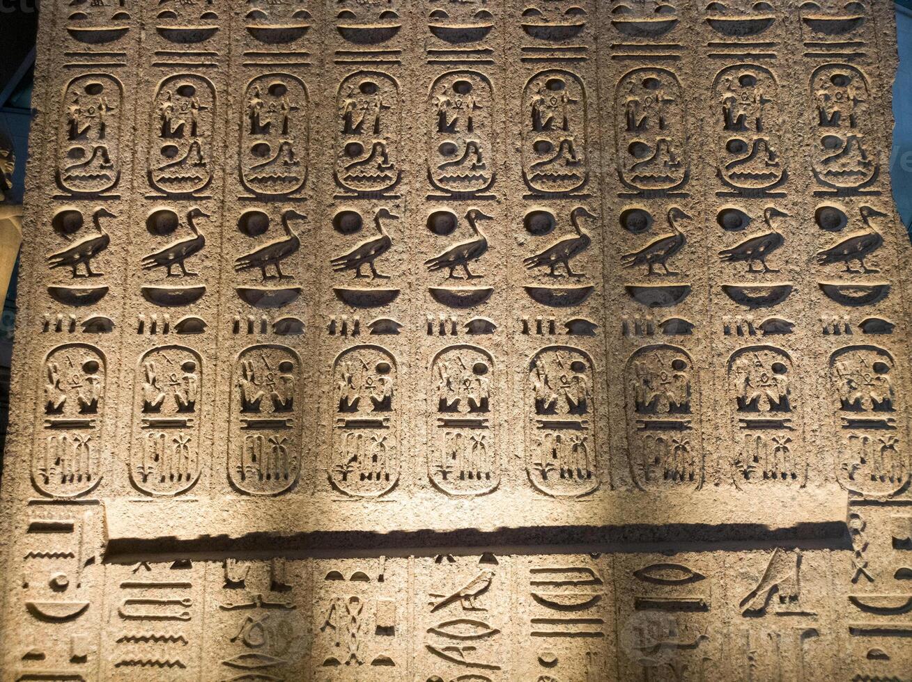 Old Egyptian hieroglyphs on an stone background. Ancient Egyptian hieroglyphs as pattern in Tombs. photo