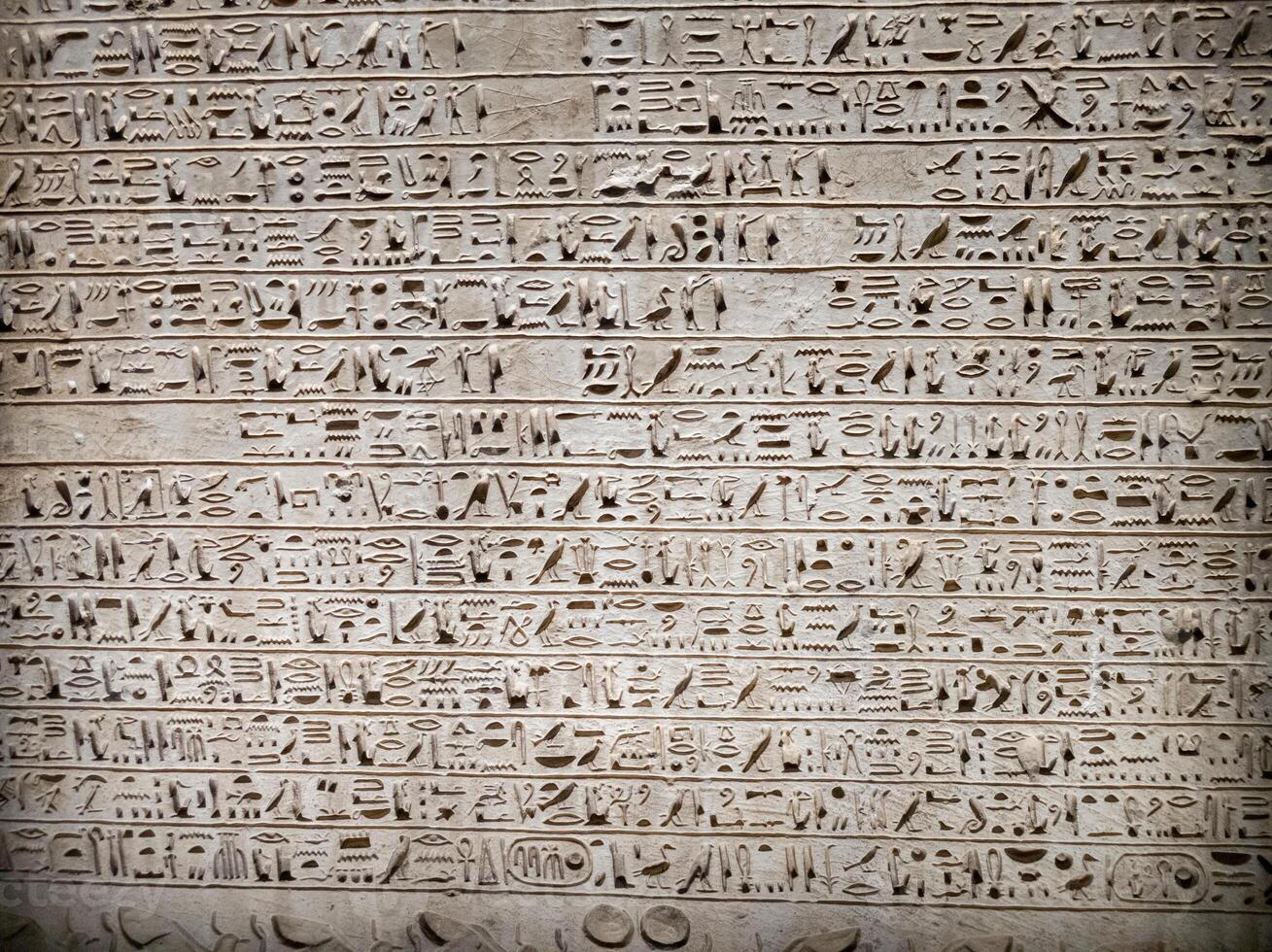 Old Egyptian hieroglyphs on an stone background. Ancient Egyptian hieroglyphs as pattern in Tombs. photo