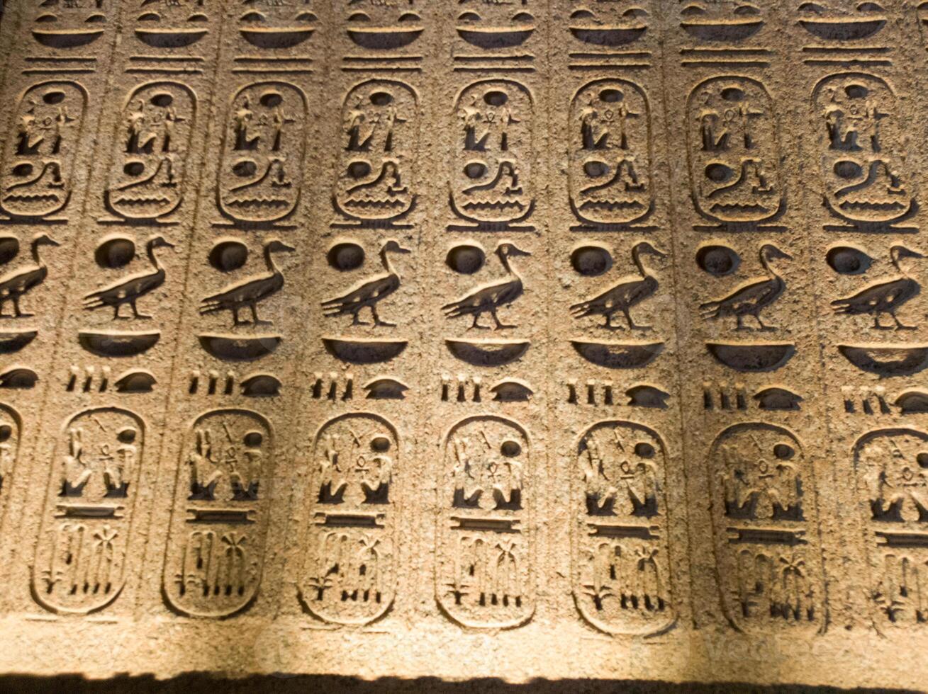 Old Egyptian hieroglyphs on an stone background. Ancient Egyptian hieroglyphs as pattern in Tombs. photo