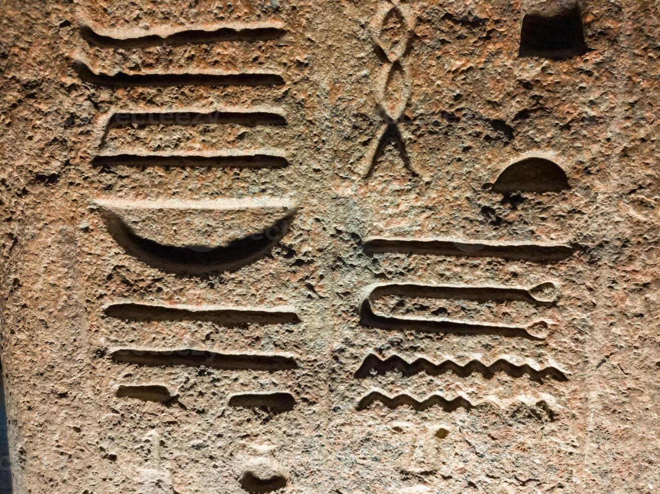 Old Egyptian hieroglyphs on an stone background. Ancient Egyptian hieroglyphs as pattern in Tombs. photo