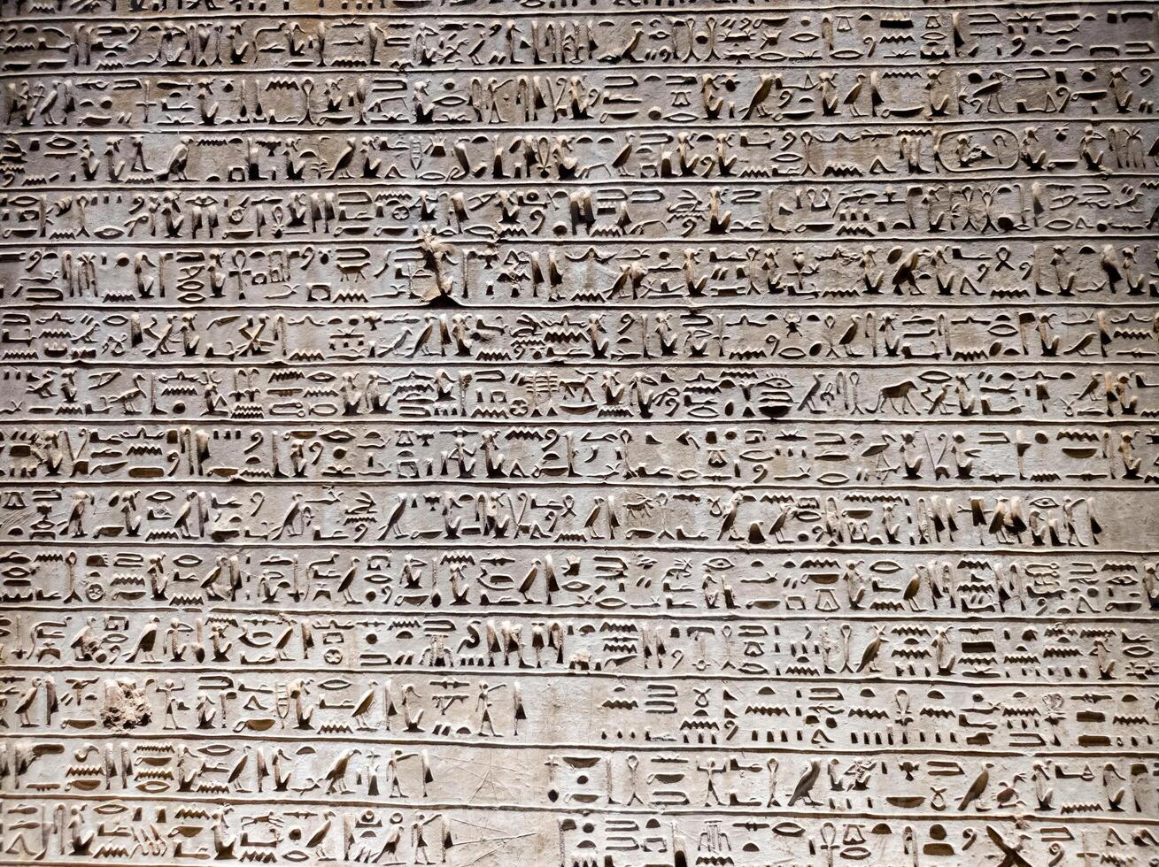 Old Egyptian hieroglyphs on an stone background. Ancient Egyptian hieroglyphs as pattern in Tombs. photo