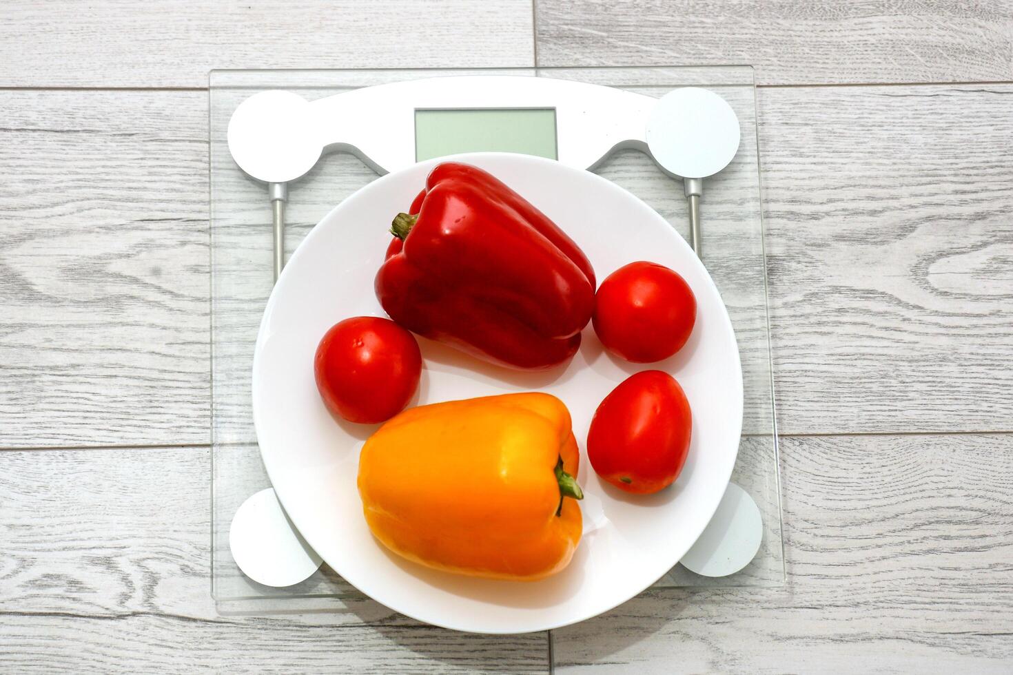 plate with fresh vegetables on scales photo