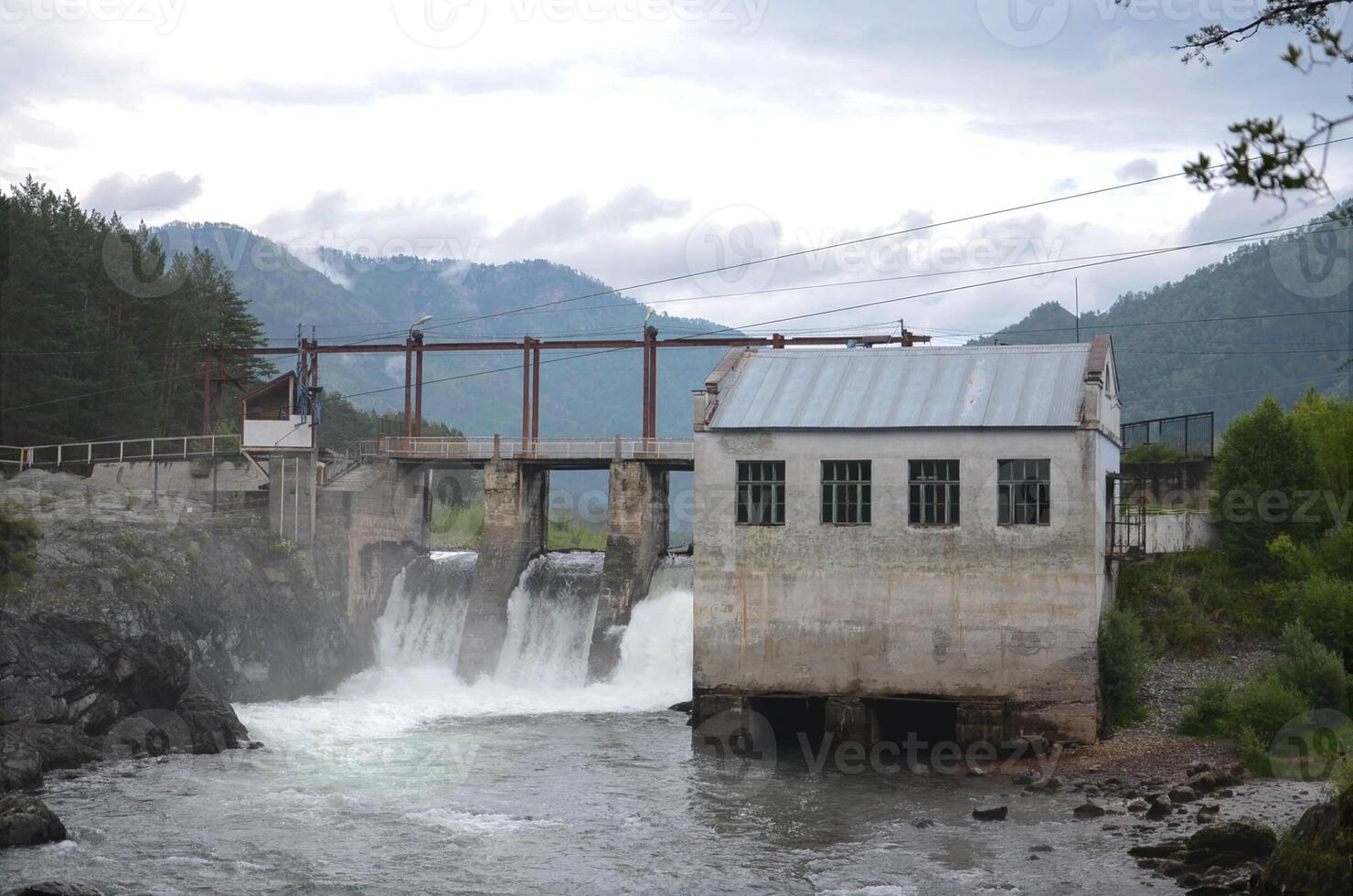 Hydroelectric power station against the backdrop of mountains, old dam photo