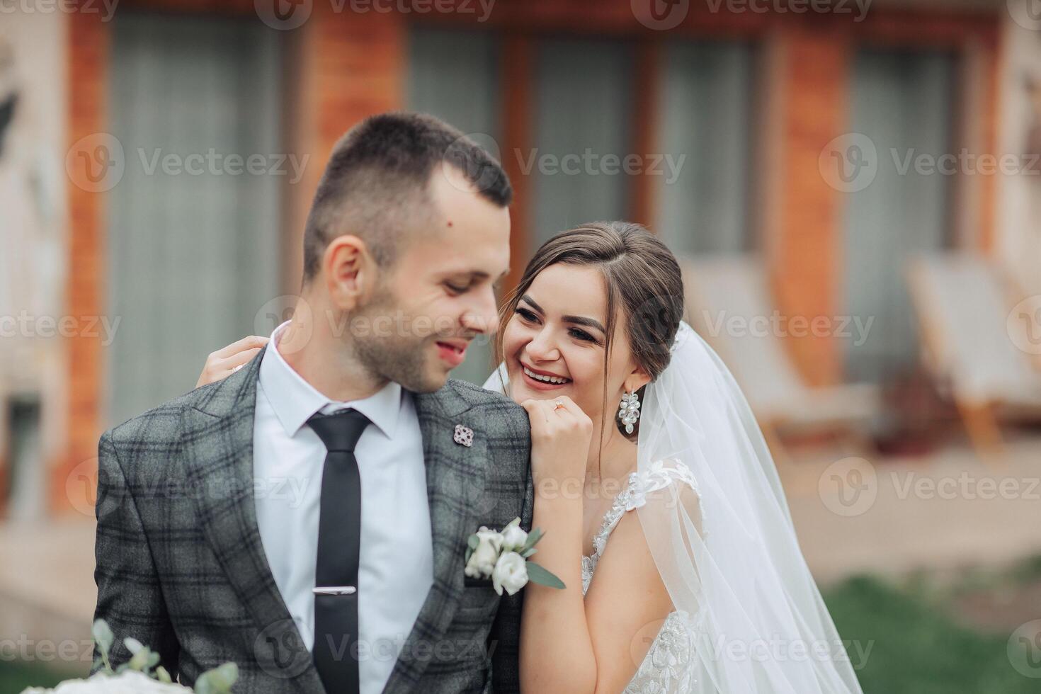 A bride and groom are smiling and hugging each other photo