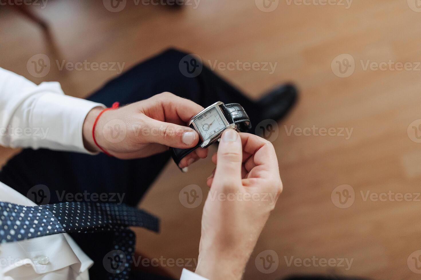A man is holding a watch in his hand photo