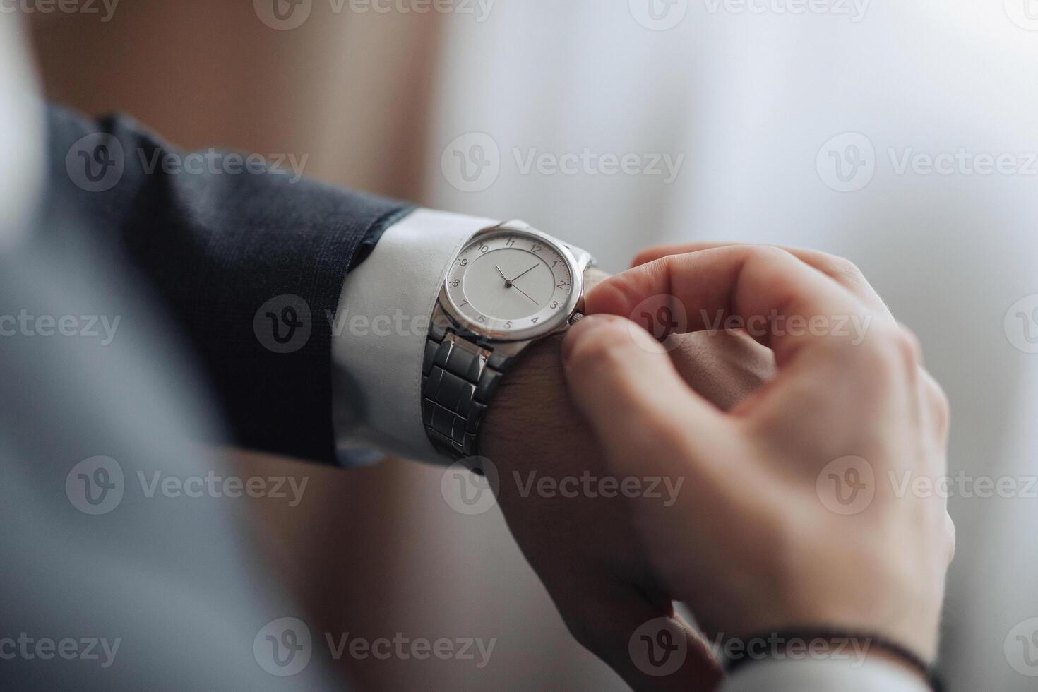 A man is wearing a watch and looking at it photo
