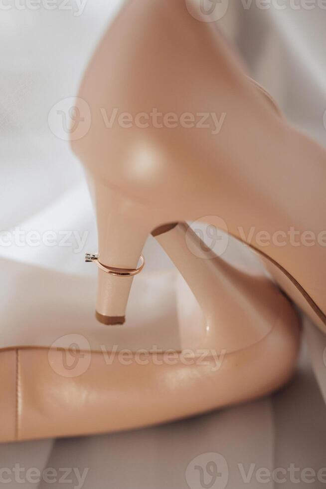 A pair of tan shoes with a ring on the toe photo